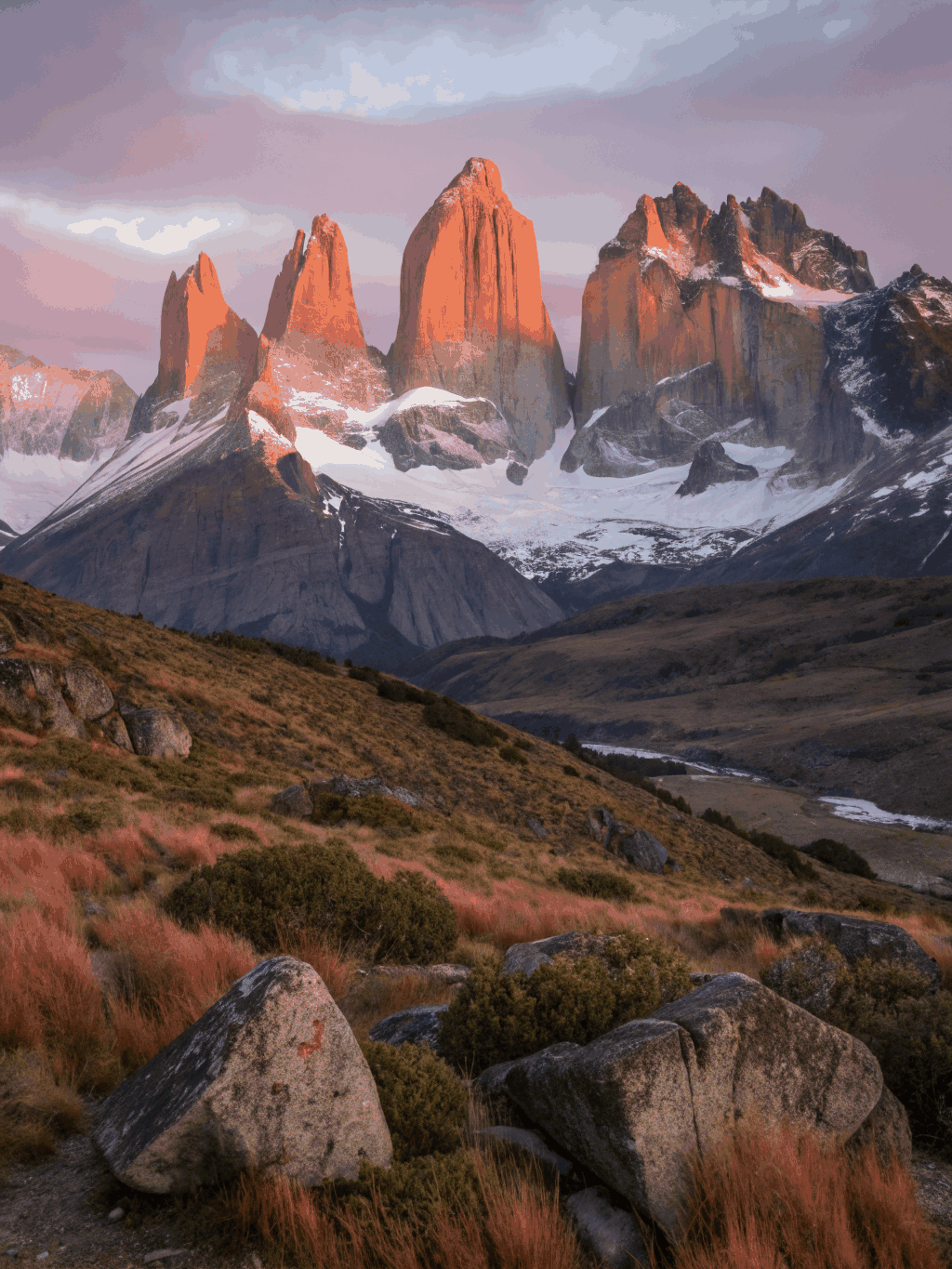 Towering granite peaks illuminated by warm golden morning light in Patagonia